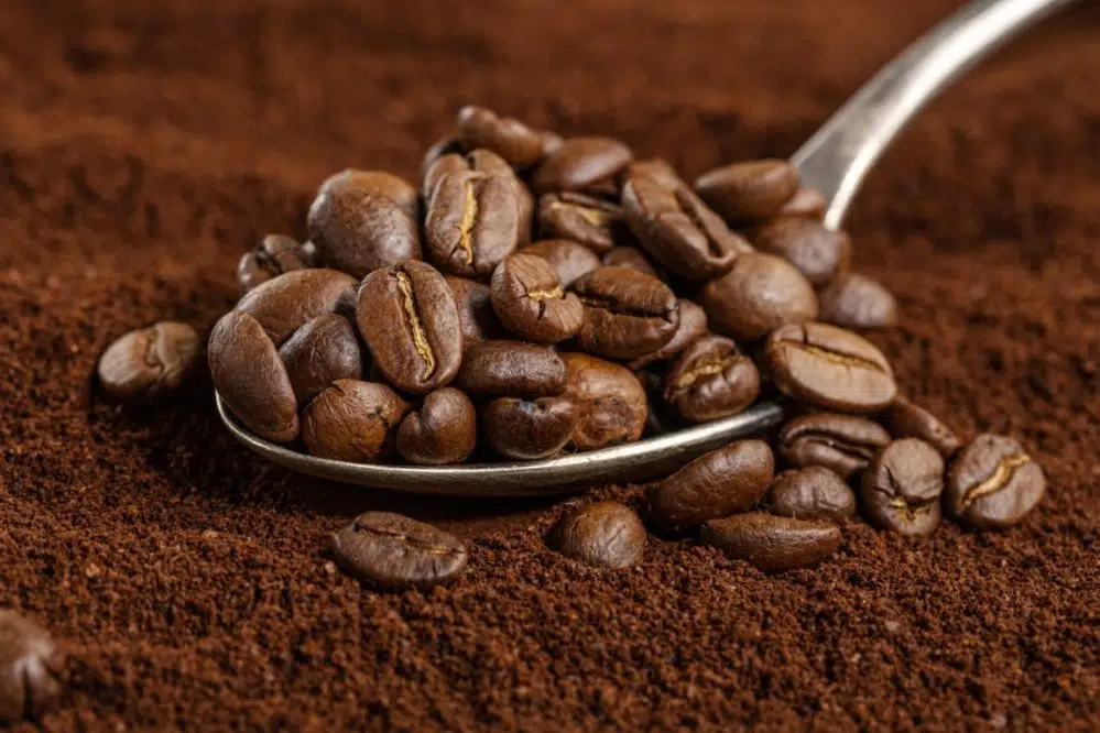 coffee beans on spoon on coffee background