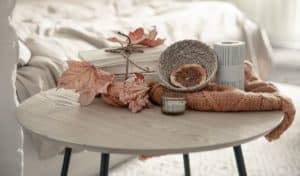 autumn composition with knitted element, dry leaves and candles.