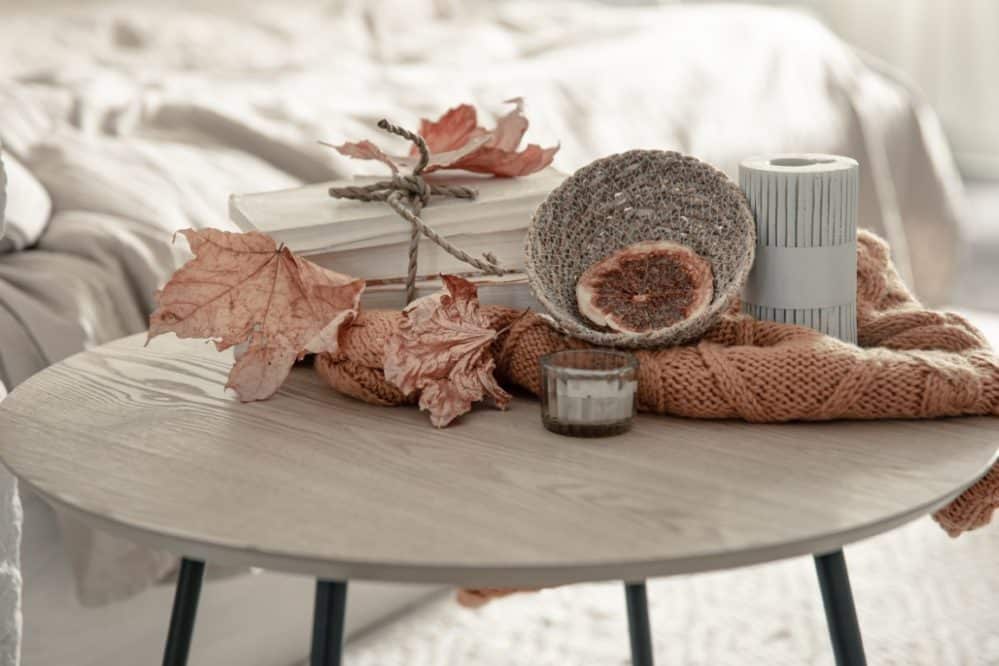 autumn composition with knitted element, dry leaves and candles.