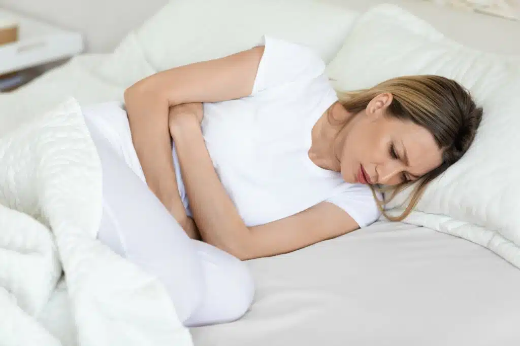 sick woman suffering from abdominal pain in the mo 2022